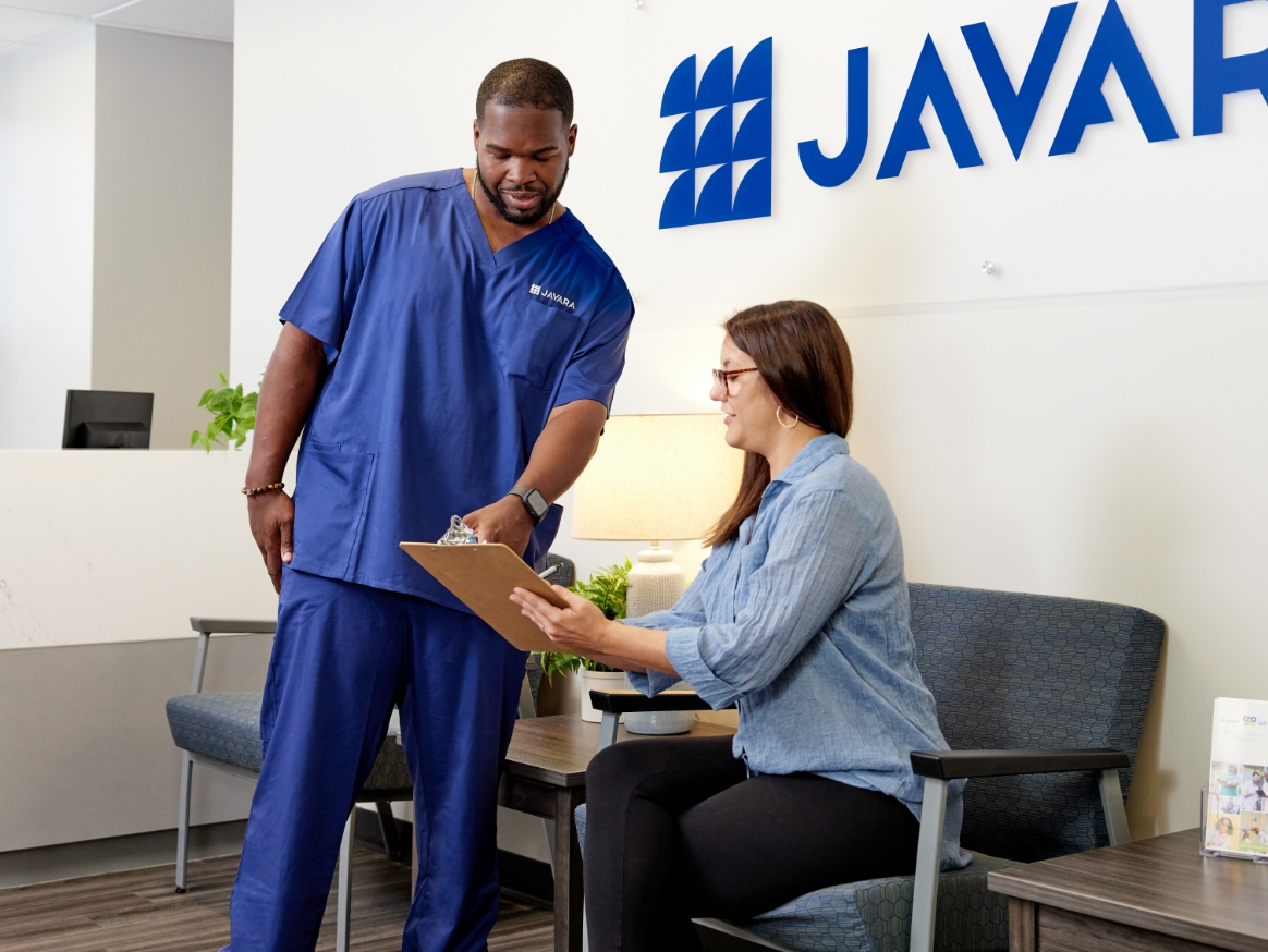 Javara employee talking to a patient in a waiting room