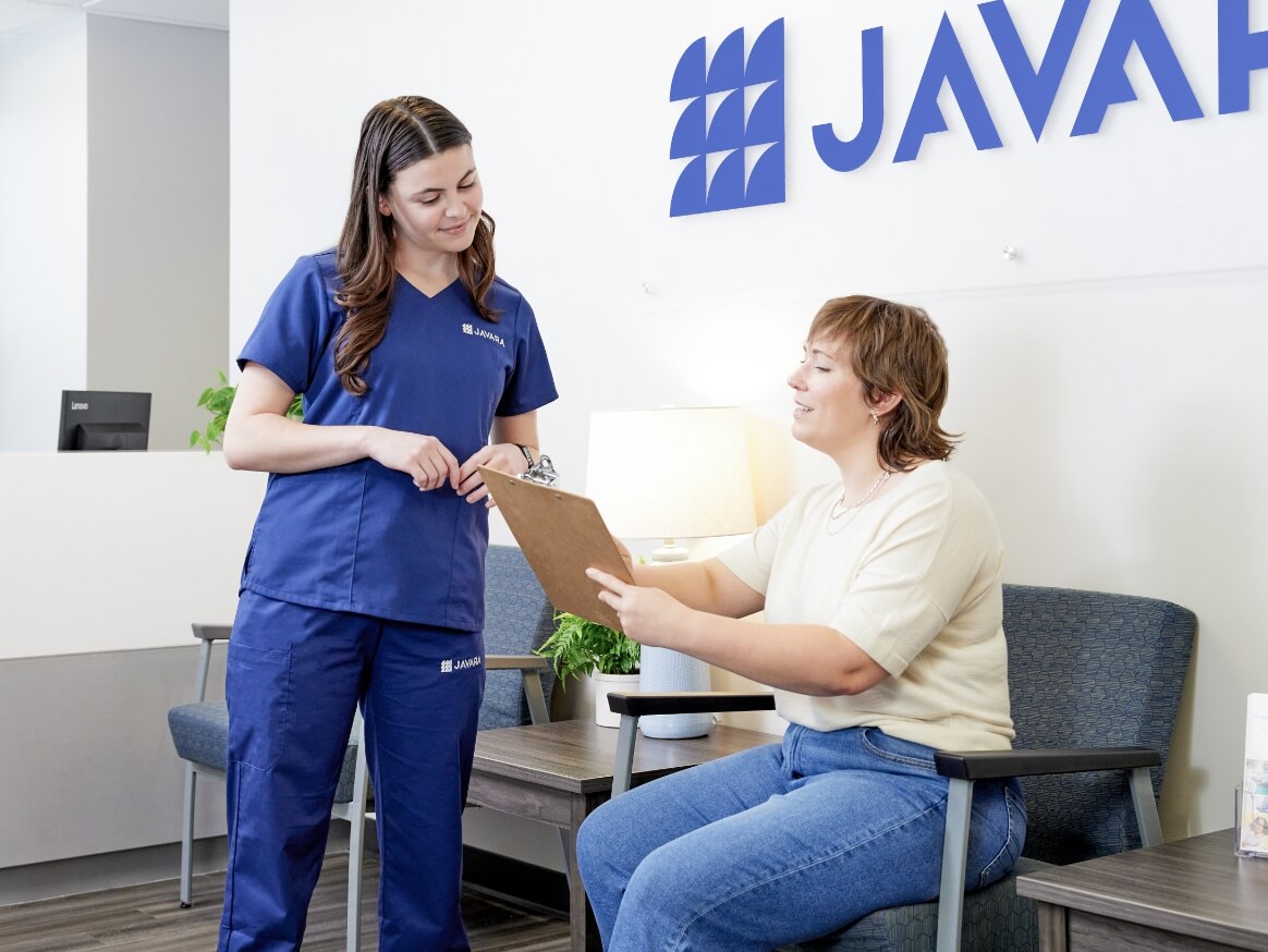 Javara employee talking to a patient in a waiting room