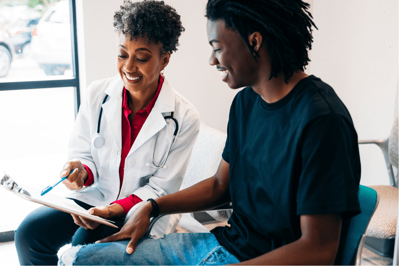 Young Black patient in conversation with doctor of same ethnic background