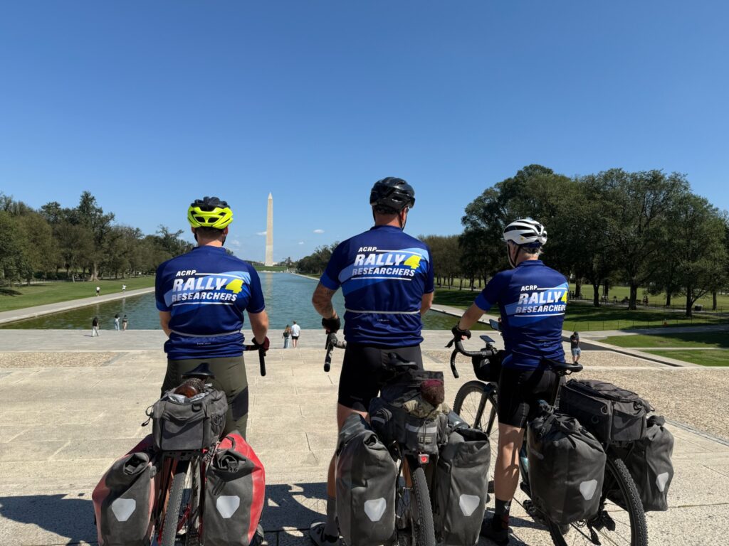 Scott Chatterton, Kyle Ashe, and Dr. David Morin wearing Rally4Researchers jerseys in Washington, D.C., celebrating the completion of the 355-mile ride supporting clinical research scholarships.